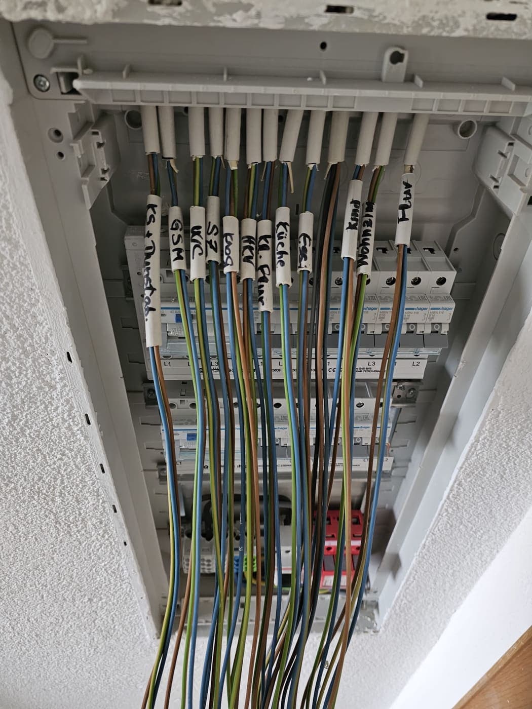 Jeder Stromkreis trägt eine beschriftete Hülse – Küche, Bad, Schlafzimmer, WC, Keller, Wohnzimmer – vor dem Auflegen.