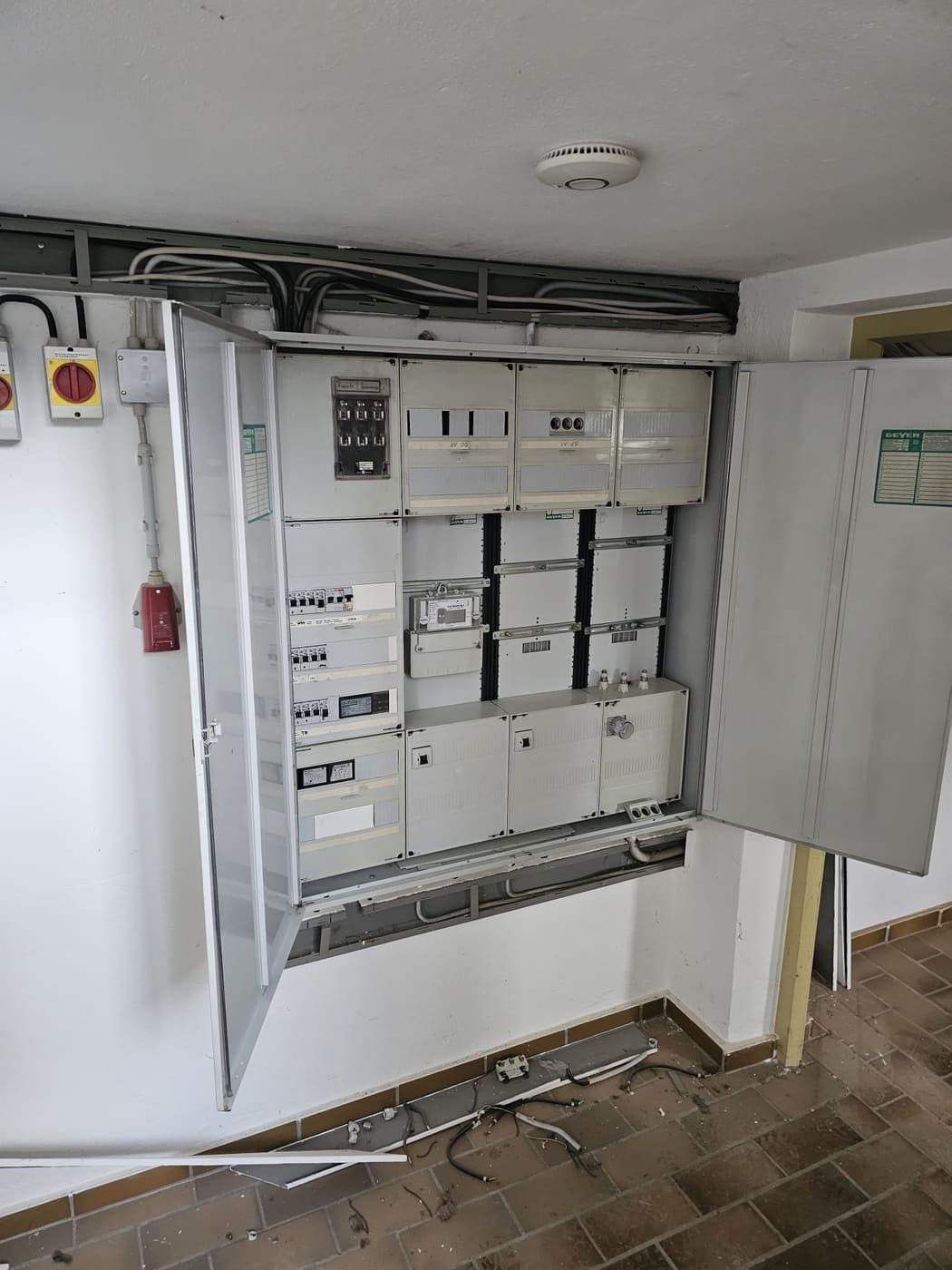 Geöffneter älterer Zählerschrank im Keller mit Zähler und den Feldern für Erd- und Obergeschoss.